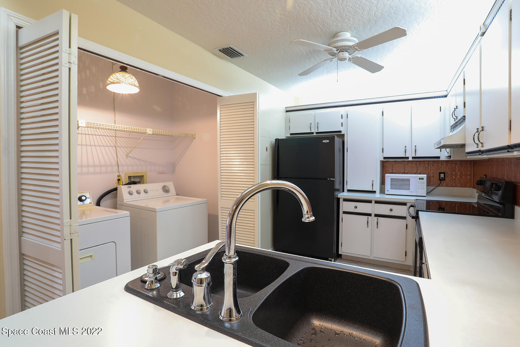 1943 Quail Ridge Court, Unit 604 Cocoa, FL 32926 - Photo 14 of 38 a kitchen with a refrigerator and a sink