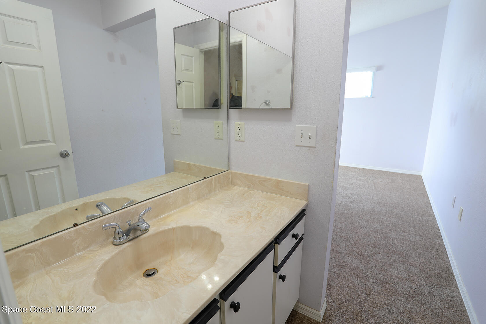 1943 Quail Ridge Court, Unit 604 Cocoa, FL 32926 - Photo 25 of 38 a bathroom with a sink and a mirror