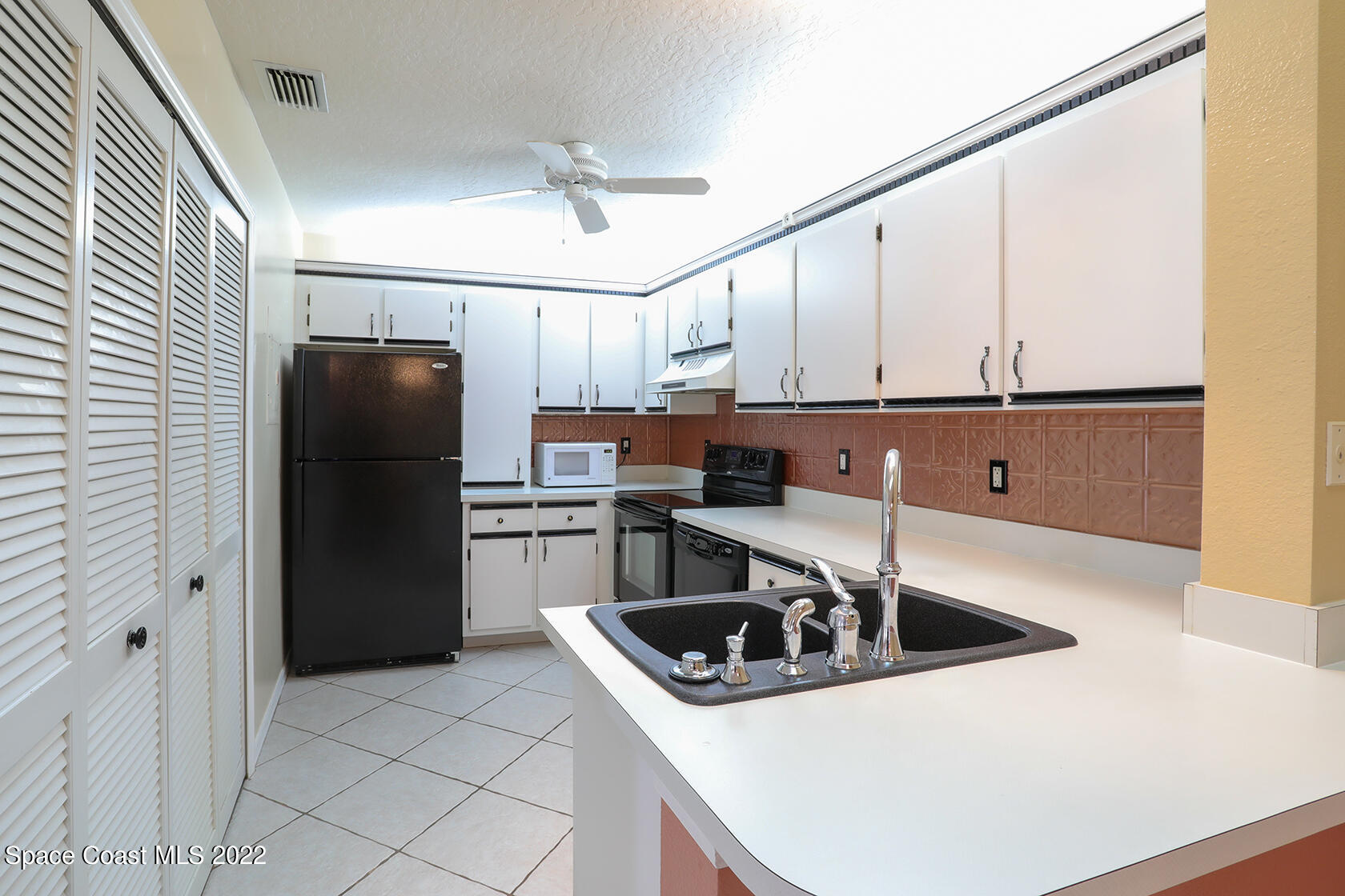 1943 Quail Ridge Court, Unit 604 Cocoa, FL 32926 - Photo 10 of 38 a kitchen with stainless steel appliances granite countertop a sink a refrigerator and a stove