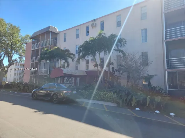 a view of a house with a yard and palm trees