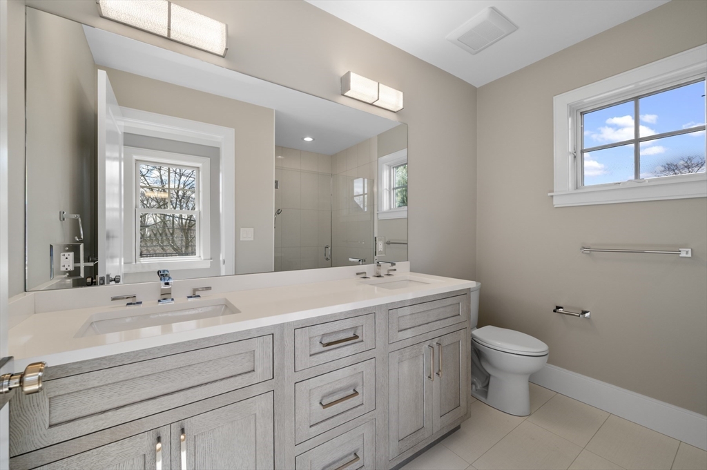 799 Heath Street, Unit 2 Brookline, MA 02467 - Photo 12 of 21 a bathroom with a double vanity sink toilet and a mirror