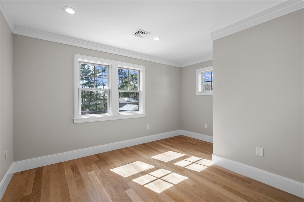 799 Heath Street, Unit 2 Brookline, MA 02467 - Photo 13 of 21 an empty room with wooden floor and windows