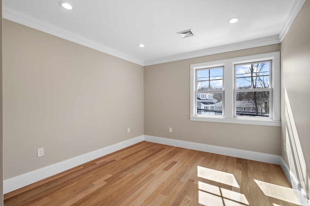 799 Heath Street, Unit 2 Brookline, MA 02467 - Photo 15 of 21 a view of empty room with wooden floor and fan