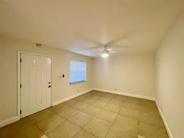 an empty room with a ceiling fan and carpet