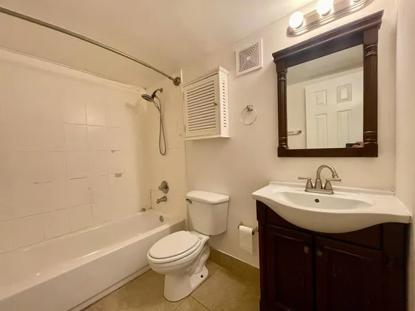 a bathroom with a toilet sink vanity tub and shower