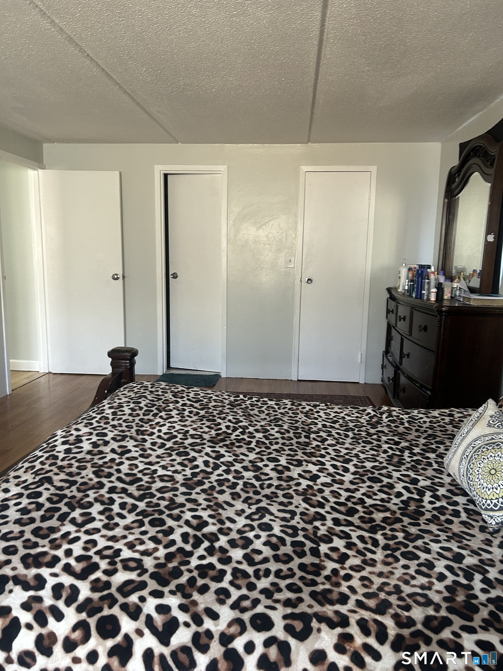 126 Triangle Street, Unit B13 Danbury, CT 06810 - Photo 16 of 20 a bedroom with a bed and wooden floor