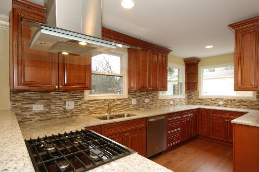 327 Bartram Road Riverside, IL 60546 - Photo 4 of 16 a kitchen with stainless steel appliances granite countertop a sink stove and cabinets