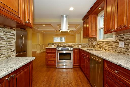 327 Bartram Road Riverside, IL 60546 - Photo 6 of 16 a large kitchen with stainless steel appliances granite countertop a stove and a sink