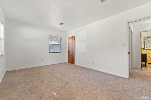 an empty room with windows and closet