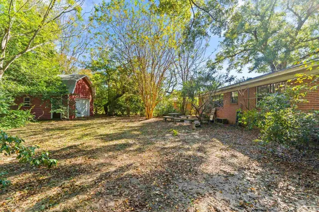 a view of a wooden house with large trees
