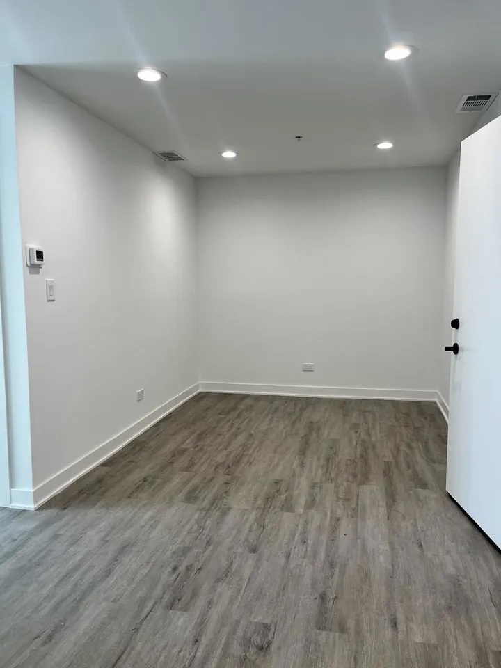 3239 Grove Avenue Berwyn, IL 60402 - Photo 6 of 16 an empty room with wooden floor and white walls