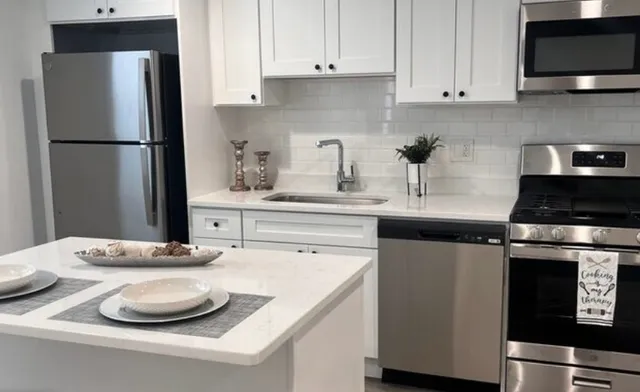 a kitchen with granite countertop a sink stove and refrigerator