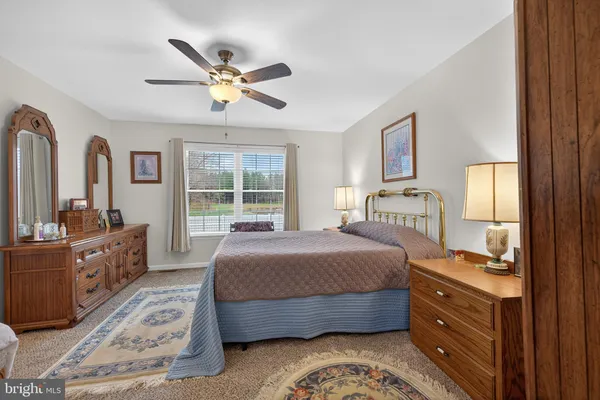 a spacious bedroom with a bed dresser and a window