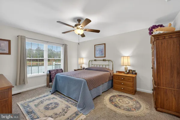 a bedroom with a large bed and ceiling fan