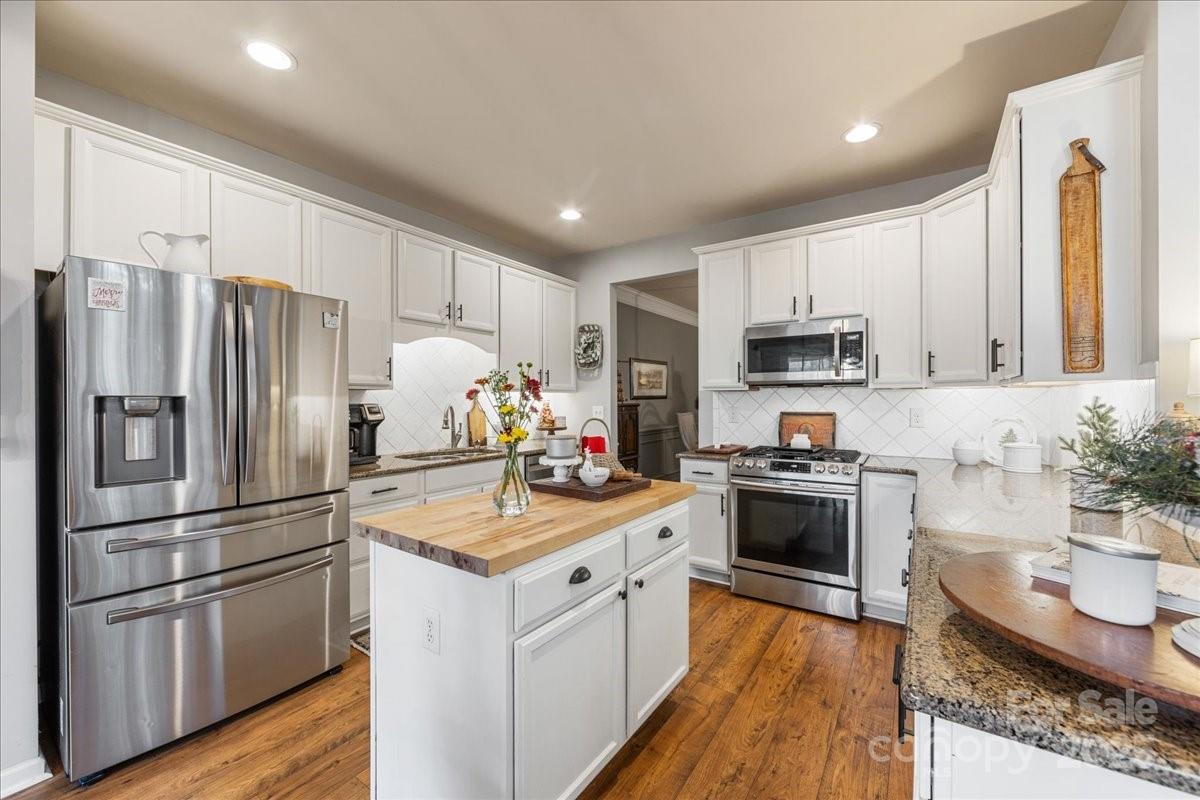 718 Deerbrook Lane Tega Cay, SC 29708 - Photo 22 of 45 a kitchen with kitchen island granite countertop stainless steel appliances and wooden cabinets