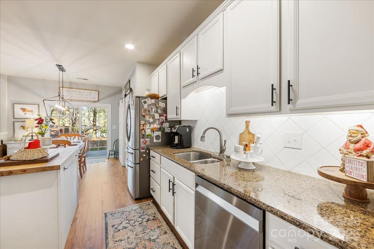 718 Deerbrook Lane Tega Cay, SC 29708 - Photo 23 of 45 a kitchen with granite countertop a sink a stove and cabinets