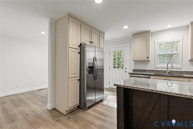 a kitchen with granite countertop a refrigerator and cabinets