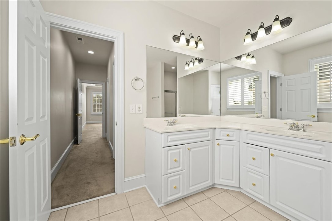 38 Angus Run Seneca, SC 29672 - Photo 32 of 46 This primary bathroom features a corner vanity with double sinks, providing ample space and functionality.
