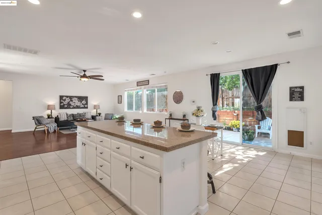 a living room with furniture kitchen view and a wooden floor