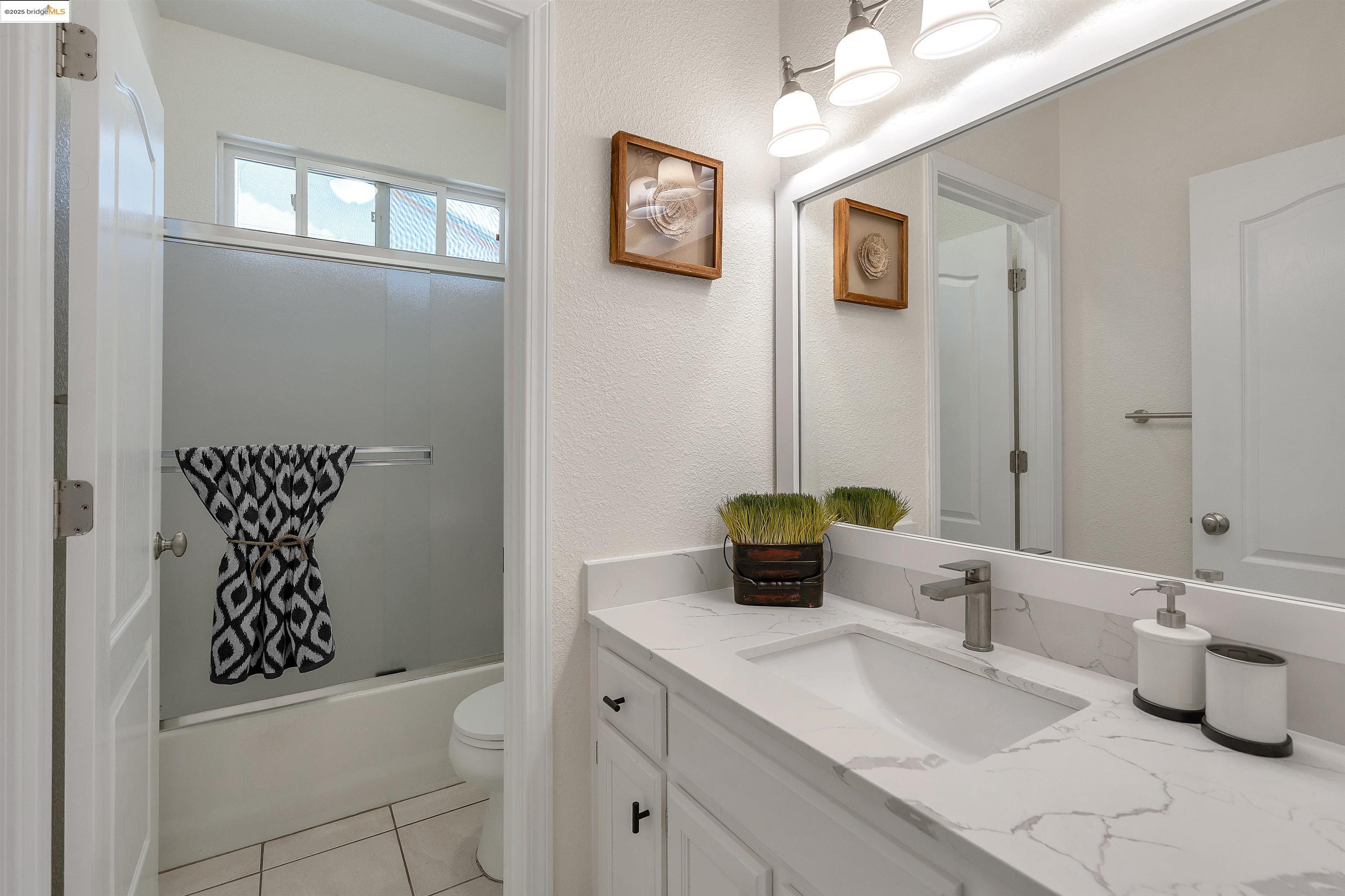 166 Rangewood Drive Pittsburg, CA 94565 - Photo 17 of 42 a bathroom with a toilet sink and mirror