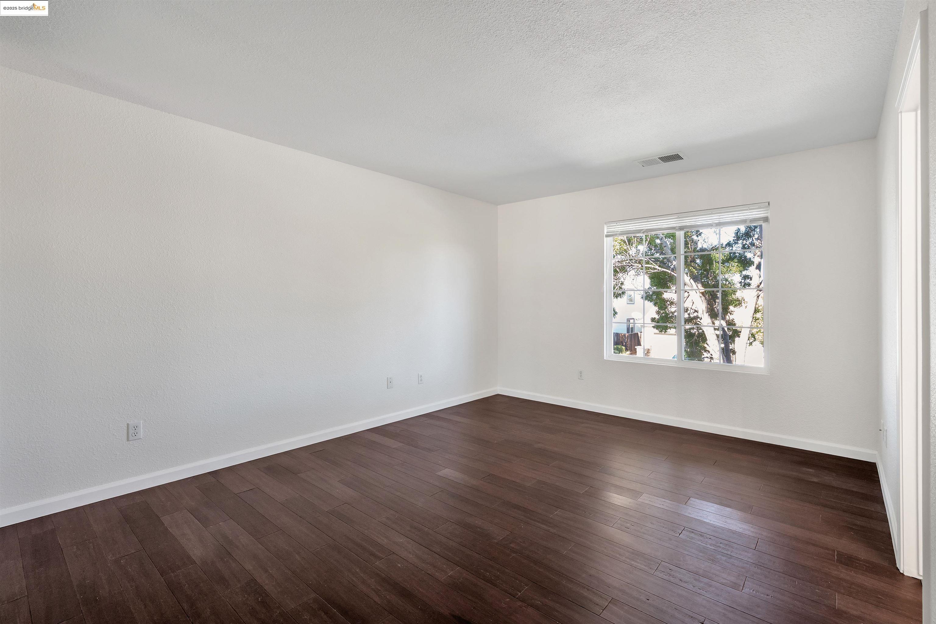 166 Rangewood Drive Pittsburg, CA 94565 - Photo 24 of 42 an empty room with wooden floor and window