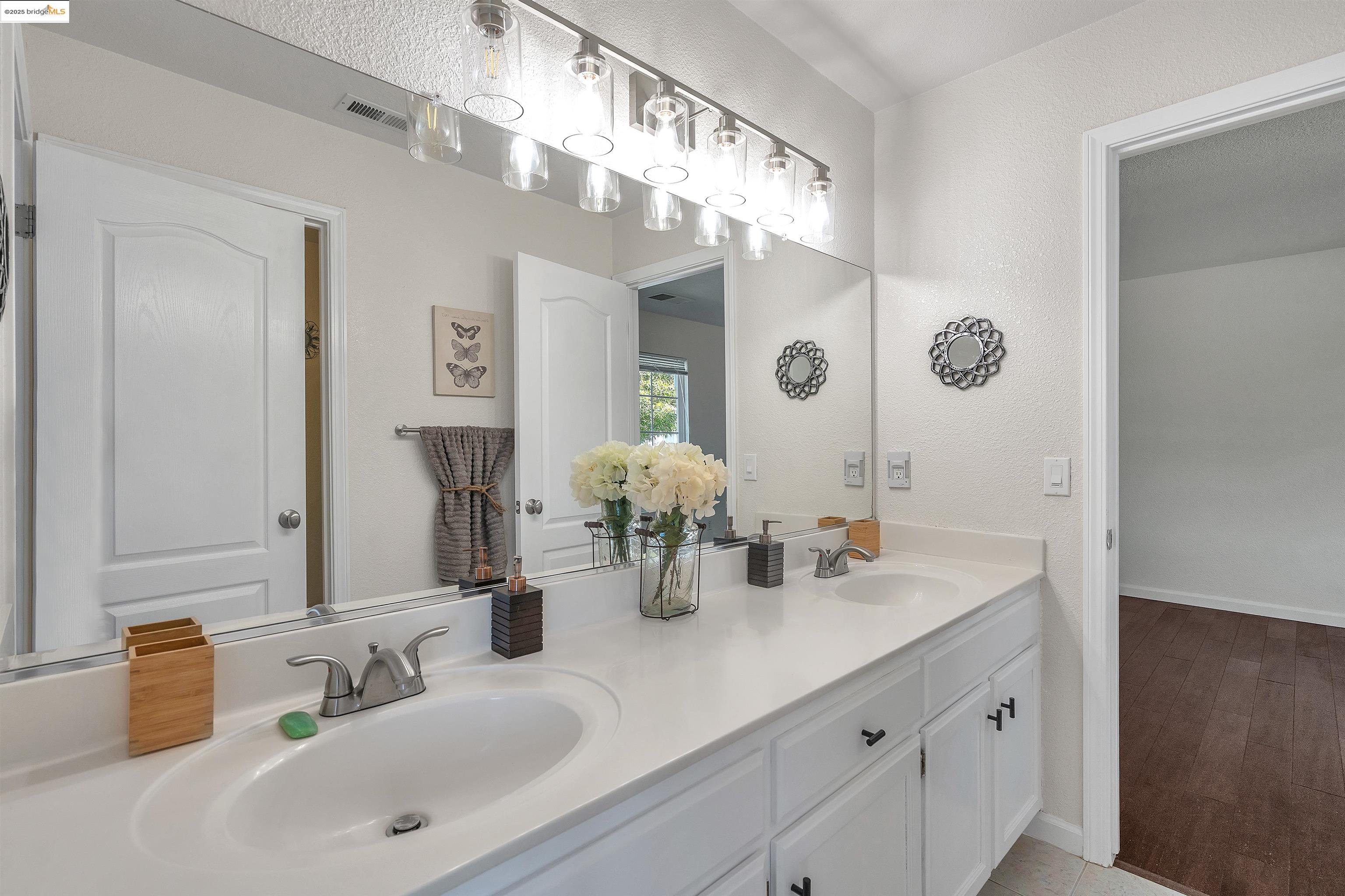166 Rangewood Drive Pittsburg, CA 94565 - Photo 25 of 42 a bathroom with double vanity sinks a vanity and a large mirror