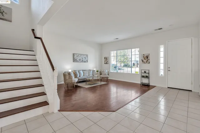 a view of an empty room with stairs and furniture