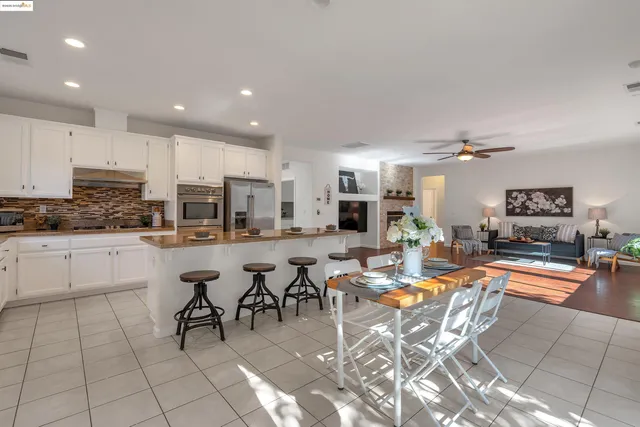 a kitchen with appliances cabinets and chair
