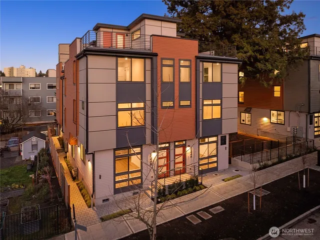 a living room with stainless steel appliances kitchen island granite countertop a refrigerator a sink dishwasher a dining table and chairs with wooden floor