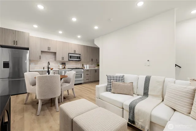 a kitchen with stainless steel appliances a table chairs and a refrigerator