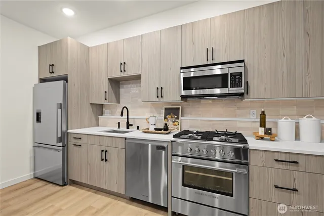 a kitchen with a stove a sink and a refrigerator