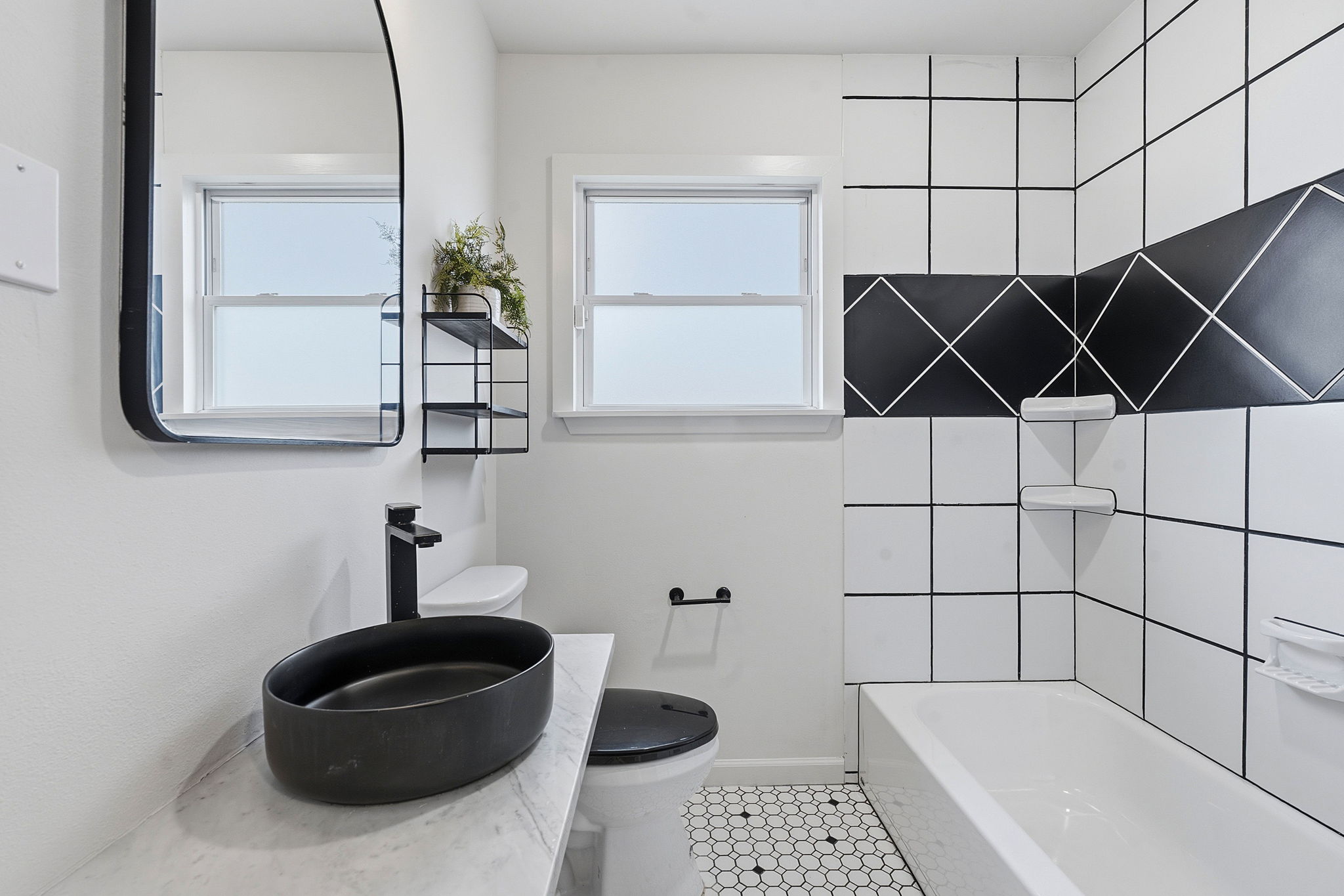 5509 Avenue F Austin, TX 78751 - Photo 23 of 40 The full guest bath in the main house is also updated with desirable contemporary finishes and comes with a shower/tub combo with designer tile backsplash.