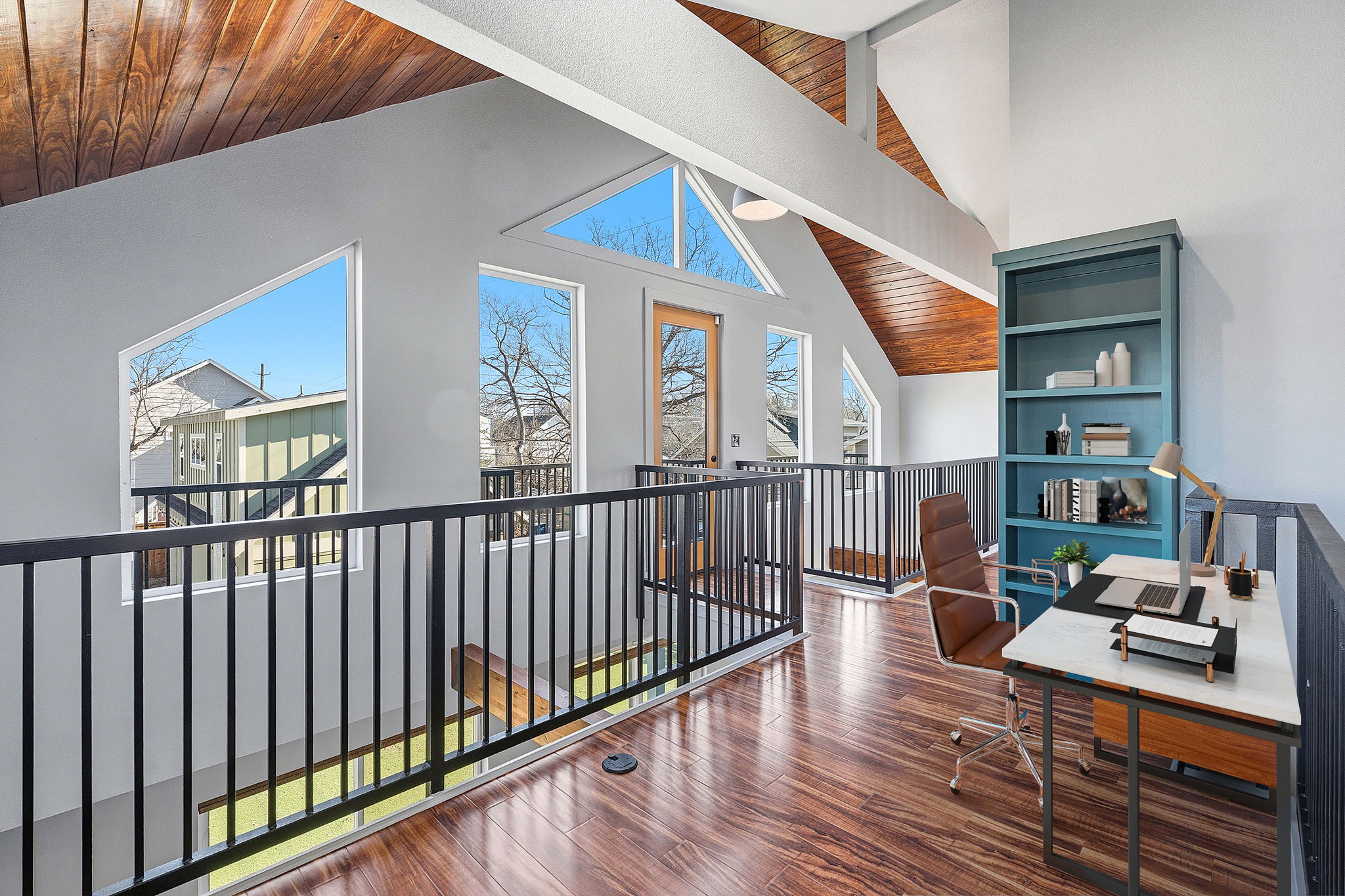 5509 Avenue F Austin, TX 78751 - Photo 33 of 40 Upstairs, vaulted wood-wrapped ceilings and iron railings define a dramatic second living space overlooking the main floor below.