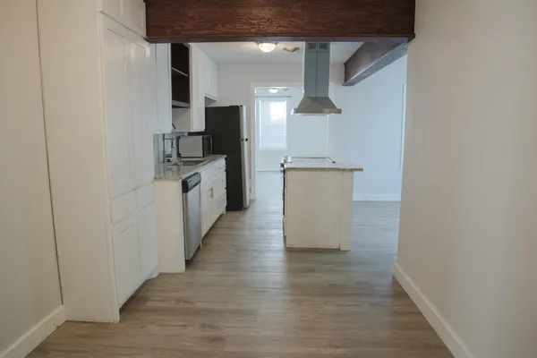 a kitchen with kitchen island granite countertop a sink stove and refrigerator
