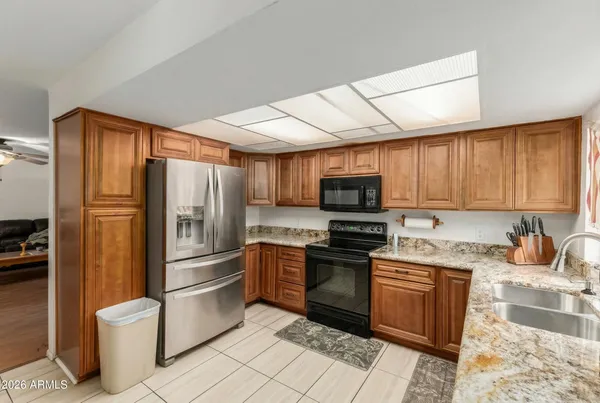 a kitchen with stainless steel appliances granite countertop a refrigerator stove and sink