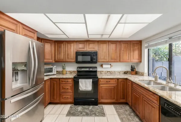 a kitchen with stainless steel appliances a stove top oven a refrigerator a sink and dishwasher
