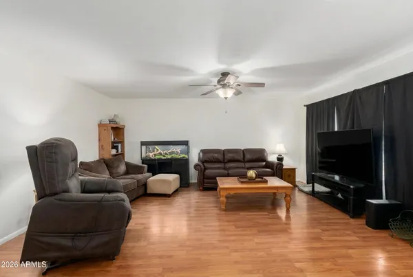 a living room with furniture a flat screen tv and kitchen view