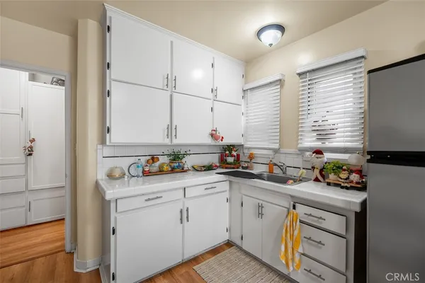 a kitchen with a refrigerator a sink dishwasher with a dining table and chairs