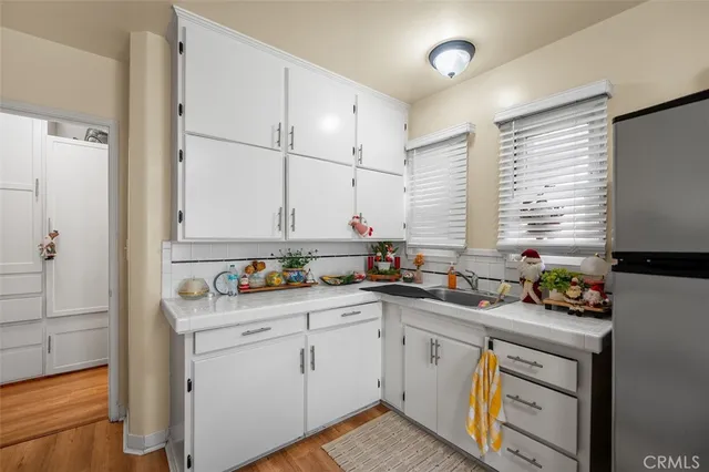 a kitchen with a refrigerator a sink dishwasher with a dining table and chairs