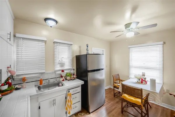 a kitchen with white cabinets and appliances