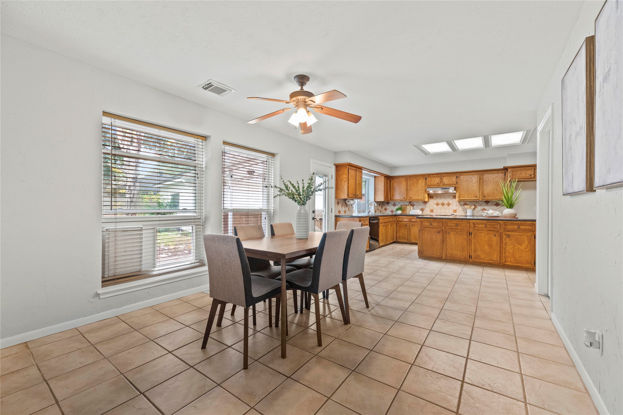 7403 Foxton Pl Court Houston, TX 77095 - Photo 11 of 41 Start your mornings with natural light and backyard views in this bright and cheerful breakfast area with tile flooring, a convenient wet bar, and a seamless flow to the family room for easy everyday living.