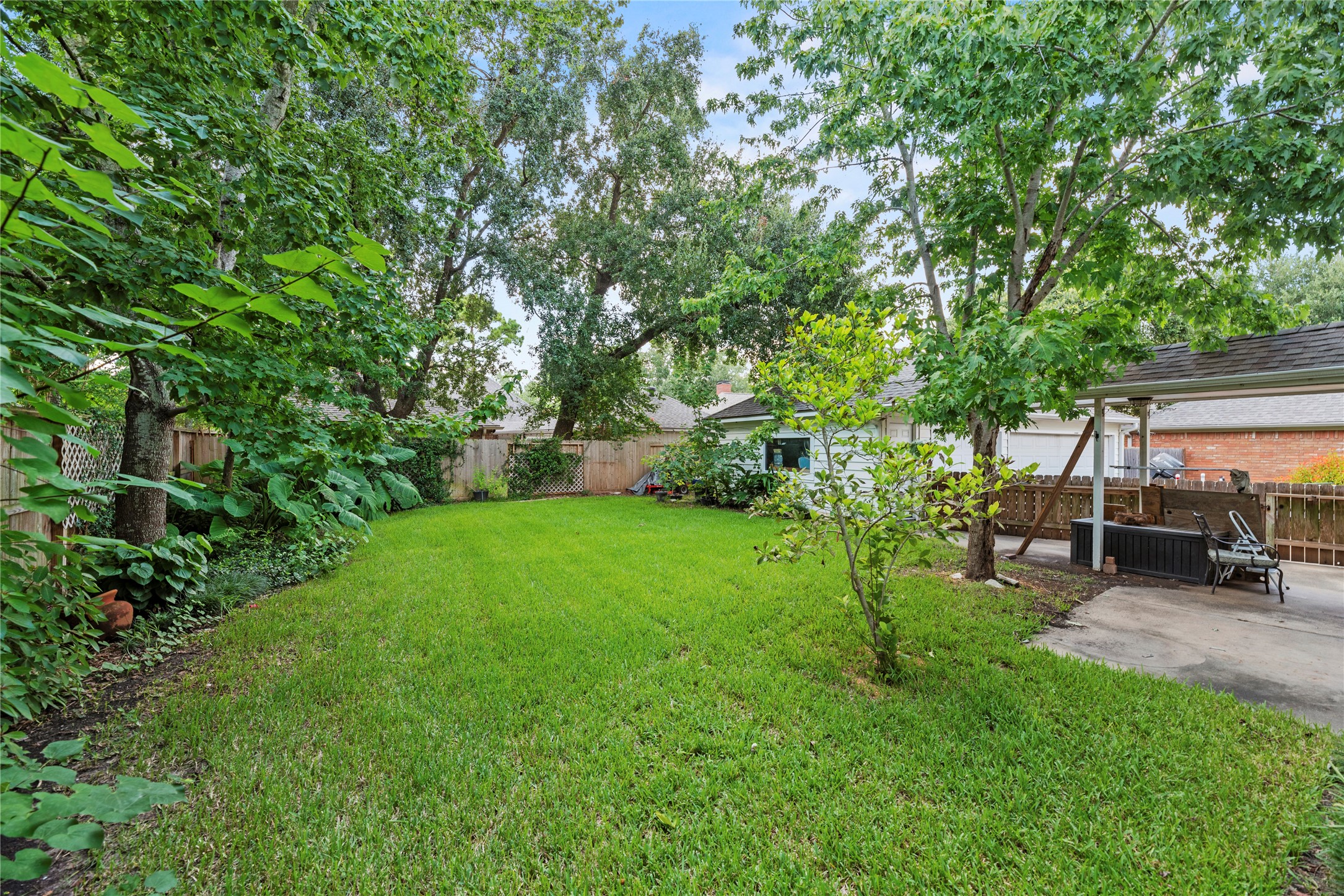 7403 Foxton Pl Court Houston, TX 77095 - Photo 28 of 41 Surrounded by mature trees and lush landscaping with a sprinkler system for easy care, the backyard offers a private retreat with plenty of green space for play, pets, and gardening.