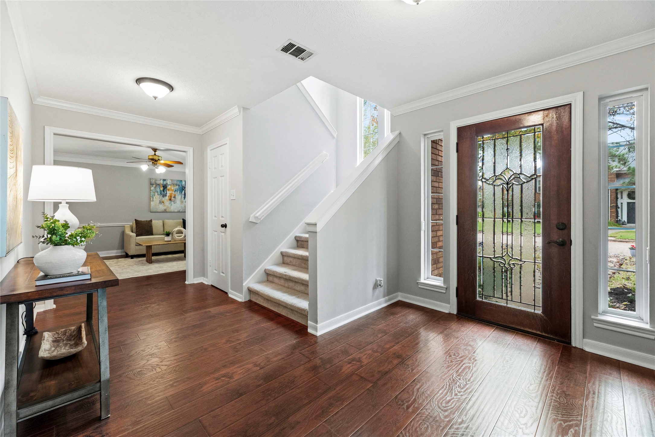 7403 Foxton Pl Court Houston, TX 77095 - Photo 5 of 41 Open and airy from the moment you arrive, the foyer showcases wood-look laminate flooring, neutral paint, and a striking leaded-glass front door. The formal dining or living is on one side of the entry and study on the other with the family room directly ahead.