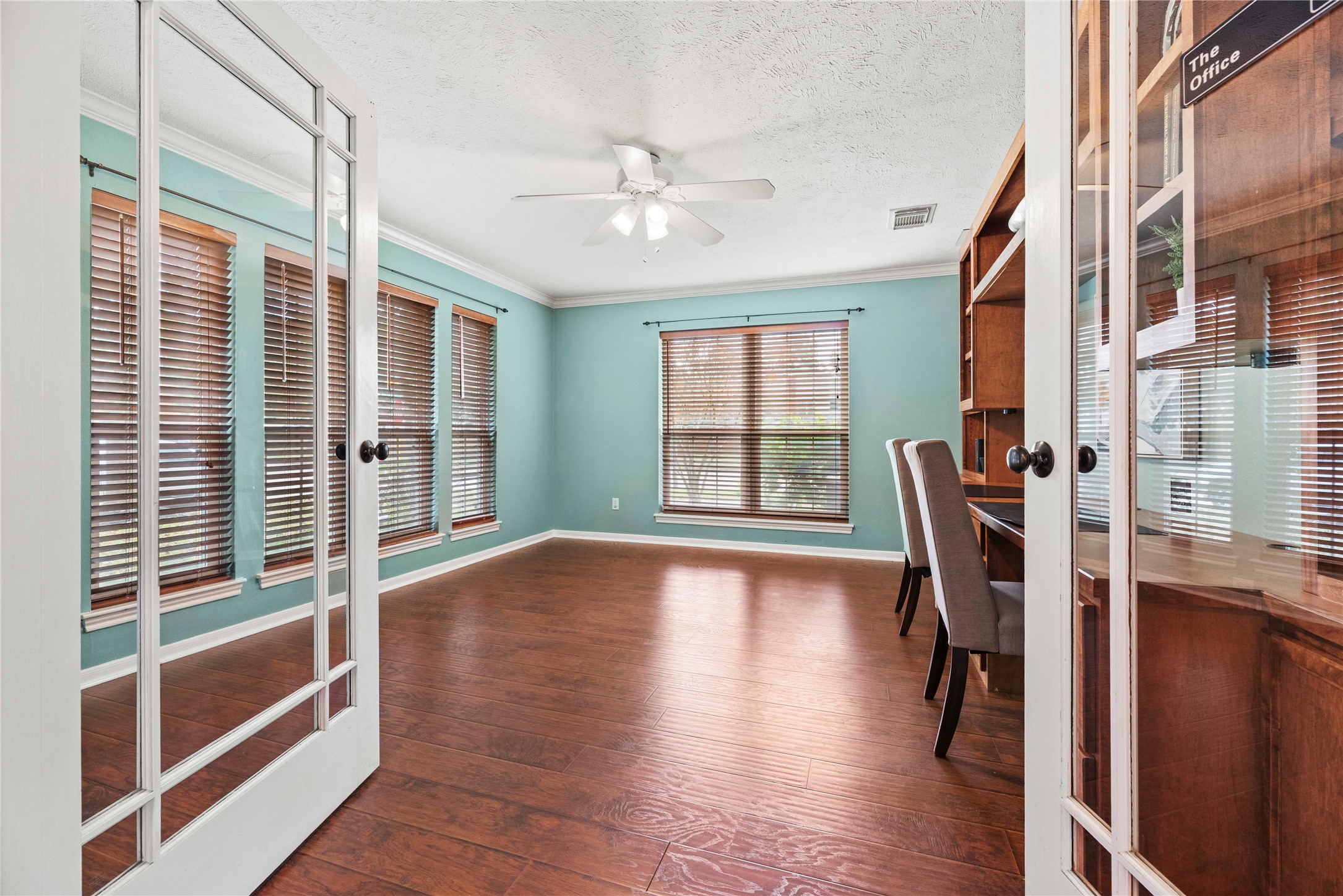 7403 Foxton Pl Court Houston, TX 77095 - Photo 6 of 41 Just another day at the office…Enjoy custom built-ins, wood look laminate flooring, crown molding, and designer paint, all framed by oversized windows with beautiful front yard views.