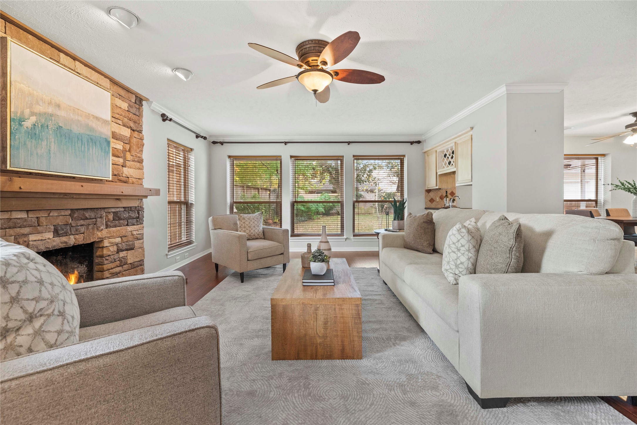 7403 Foxton Pl Court Houston, TX 77095 - Photo 9 of 41 Open the door to comfort and connection in this light-filled home, where a charming stone fireplace adds warmth and character and wide windows invite in peaceful backyard views. Warm floors, soft neutral finishes, and an open layout create an inviting space that feels just right for everyday living and easy gatherings.