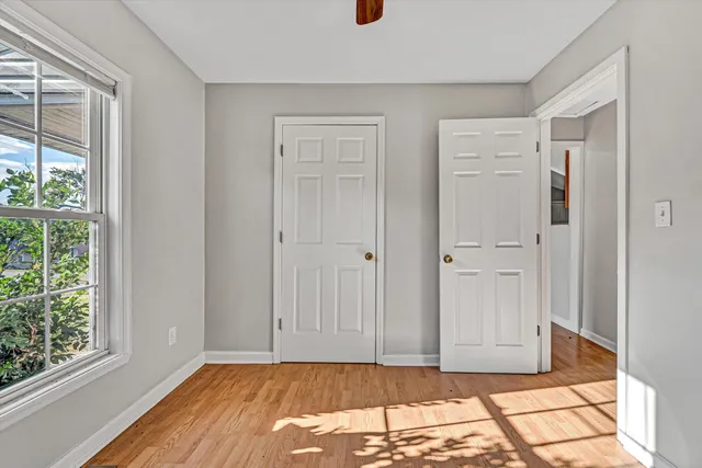 a view of empty room with window and wooden floor