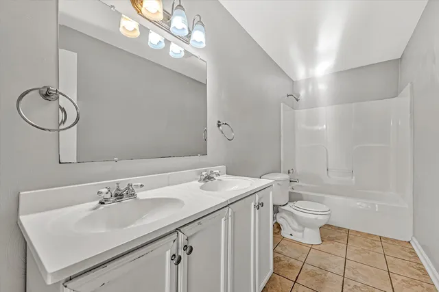 a bathroom with a double vanity sink mirror and toilet