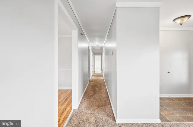 an empty room with wooden floor closet and windows