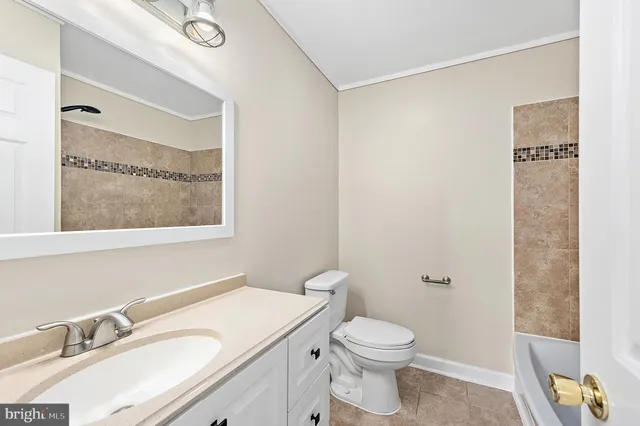 an empty room with wooden floor ceiling fan and windows