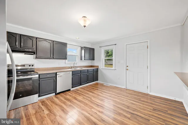 a view of a room with wooden floor ceiling fan and window